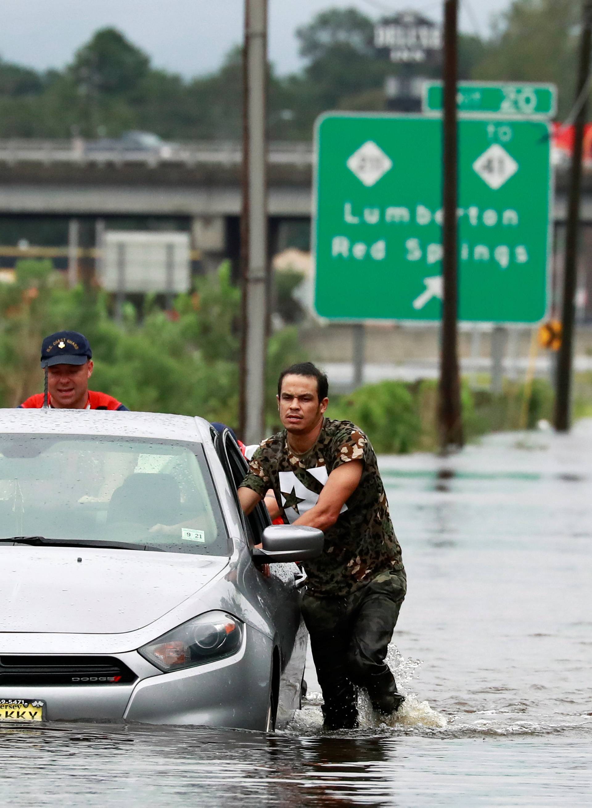 Members of the Coast Guard help a stranded motorist in the flood waters caused by Hurricane Florence in Lumberton