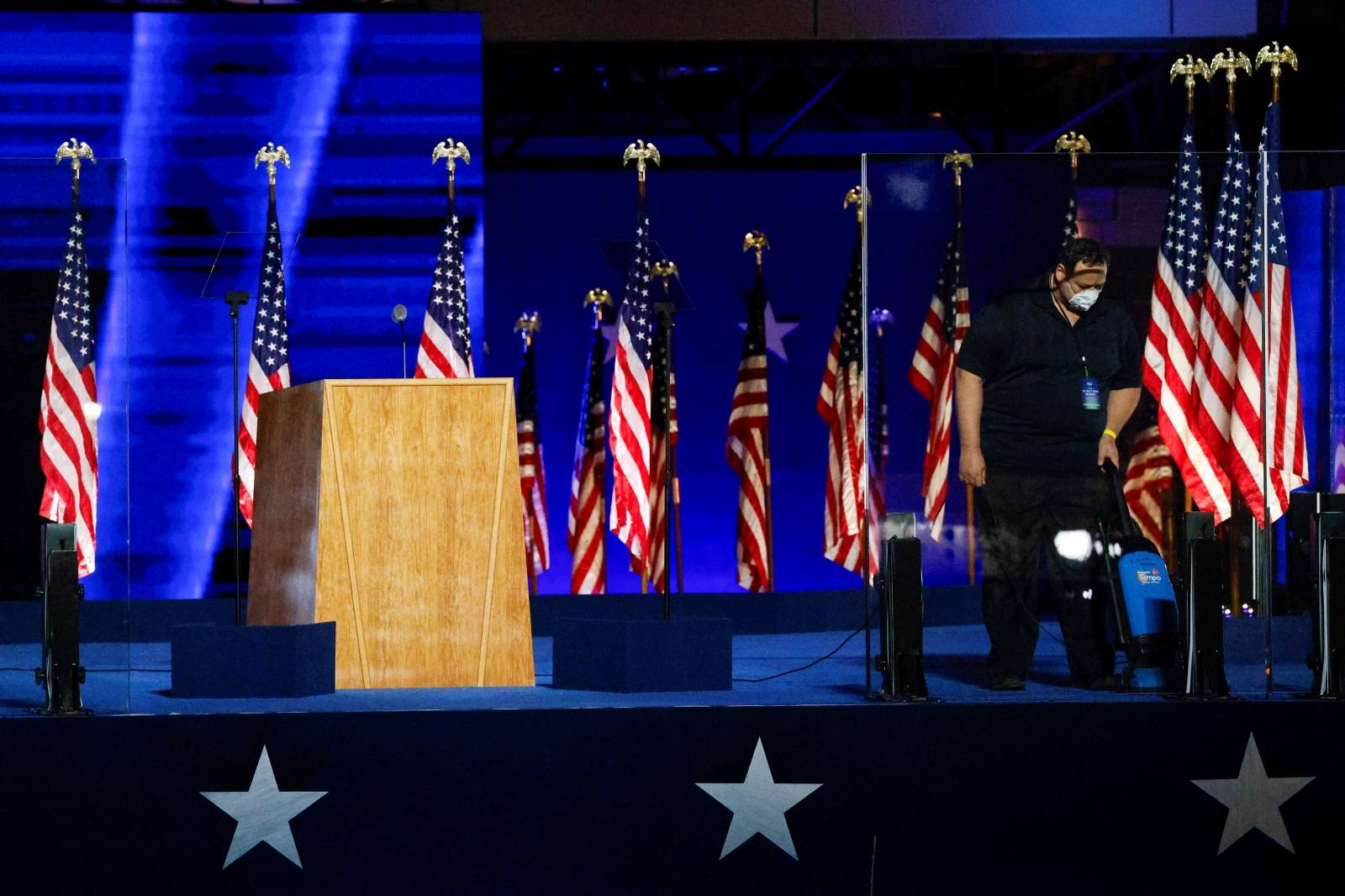 A worker vacuums the  stage area where  U.S. president-elect Joe Biden and will speak later this evening in Wilmington, Delaware