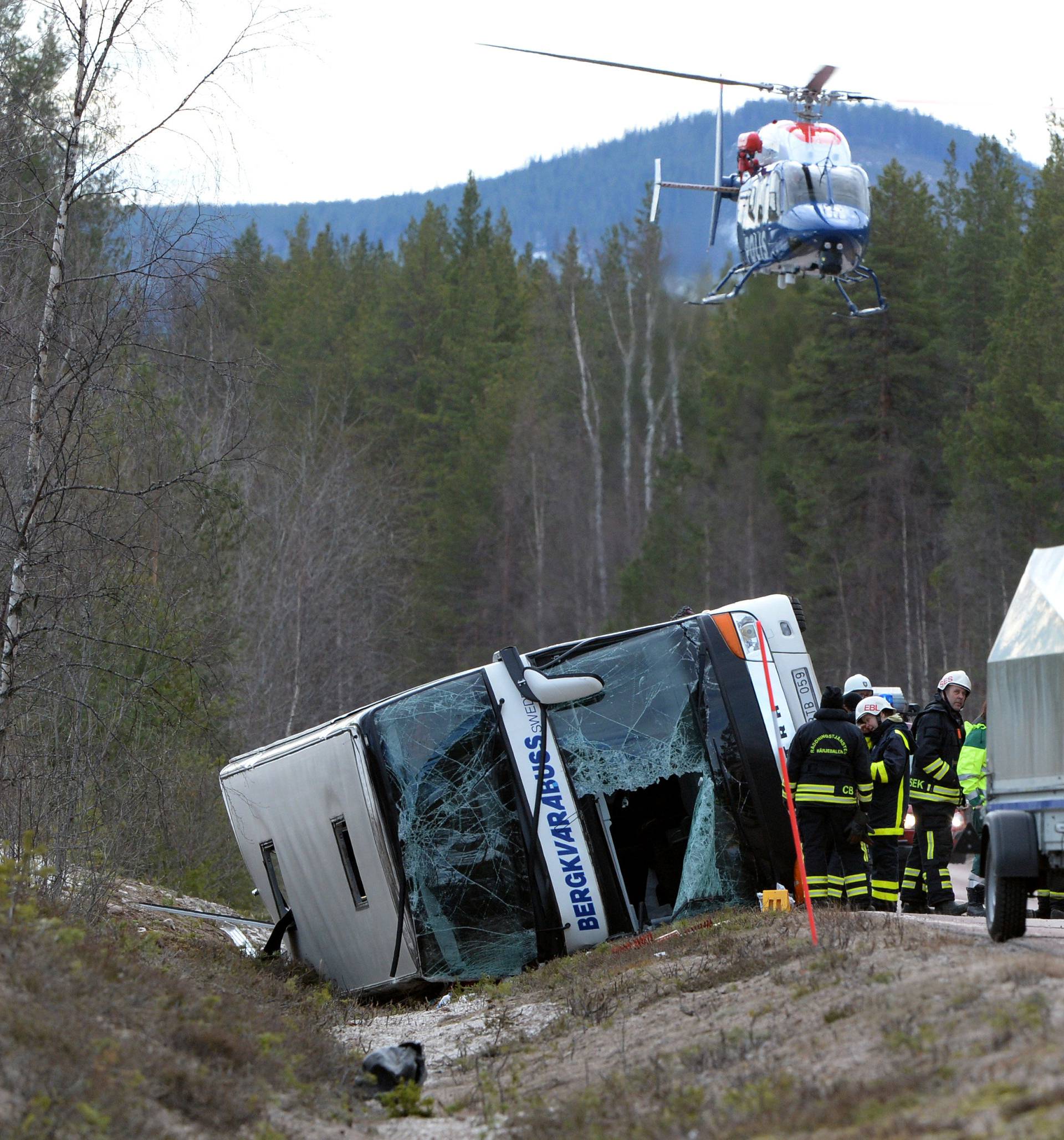 Rescue workers are seen at the site where a bus carrying school children and adults rolled over on a road close to the town of Sveg