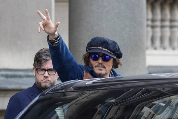 Actor Johnny Depp waves to the fans after meeting with Serbian President Aleksandar Vucic in front of his office in Belgrade