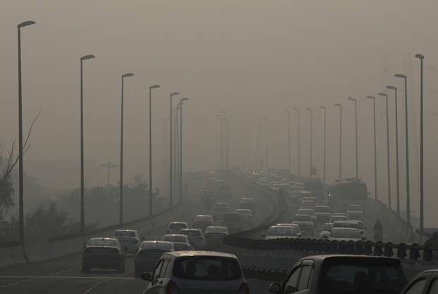 FILE PHOTO: Vehicles drive through the smog in New Delhi