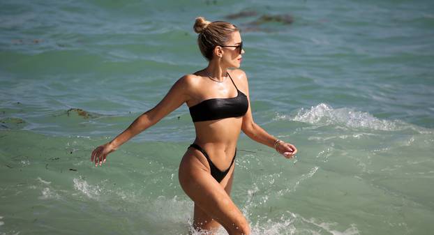 Sylvie Meis wears a black bikini and red lipstick as she hits the beach in Miami