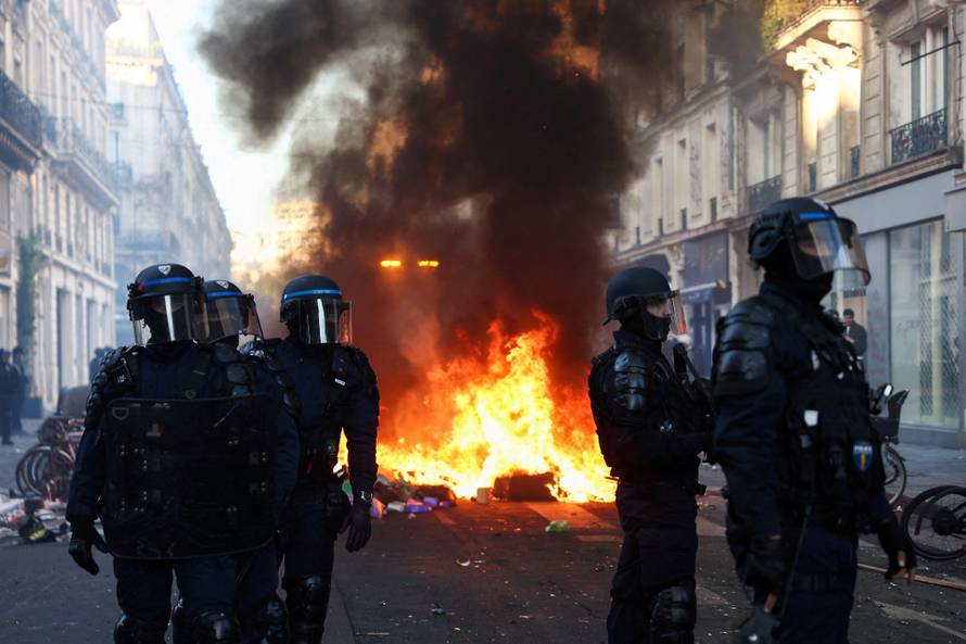 Police officers in riot gear stand guard, the day after a national day of demonstrations against the cost of living and rising fuel prices, in Paris