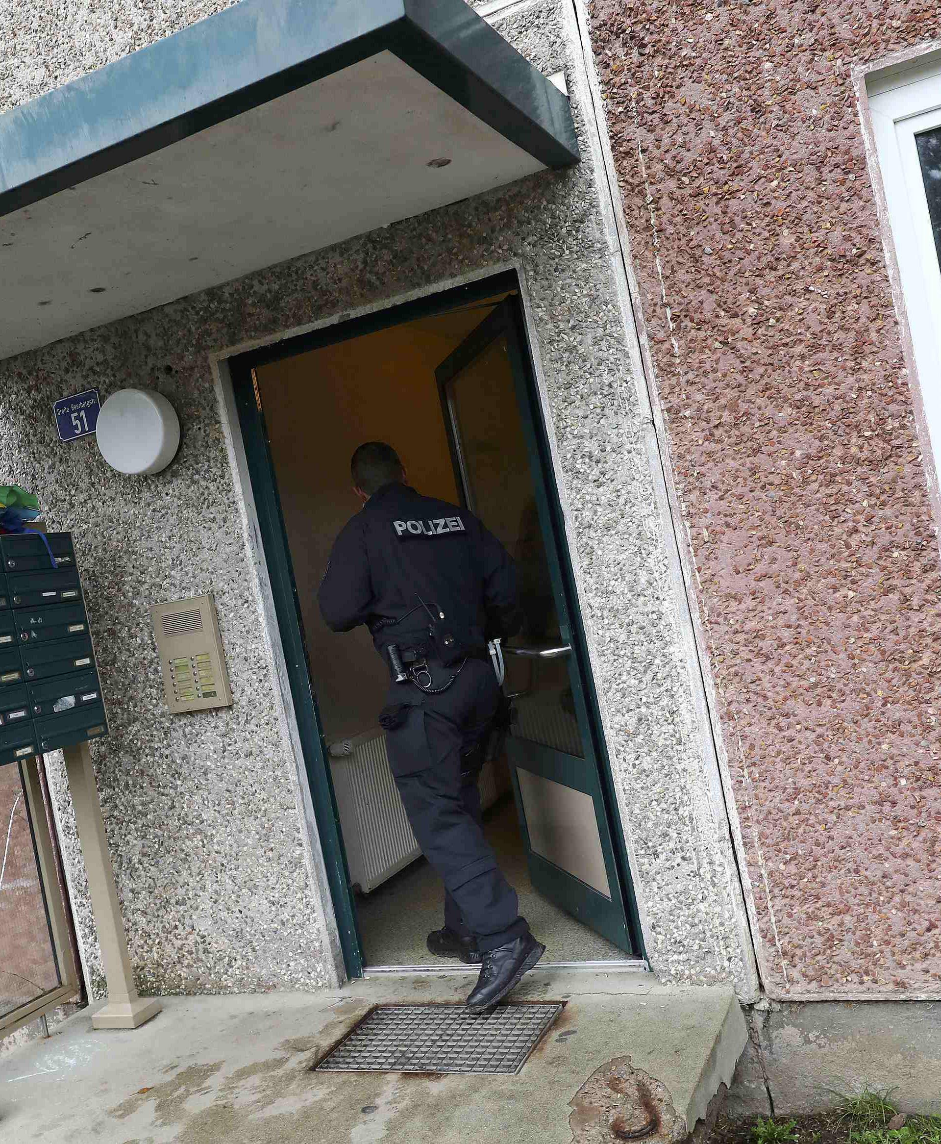 German police officer enters a building, that also serves as an accommodation facility for refugees, in Suhl