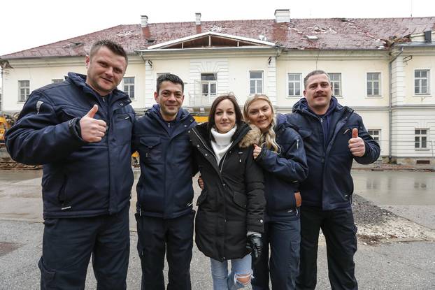 Vatrogasci s mladom djevojkom koju su izvukli iz ruševina nakon potresa koji je zadesio Petrinju prošle godine