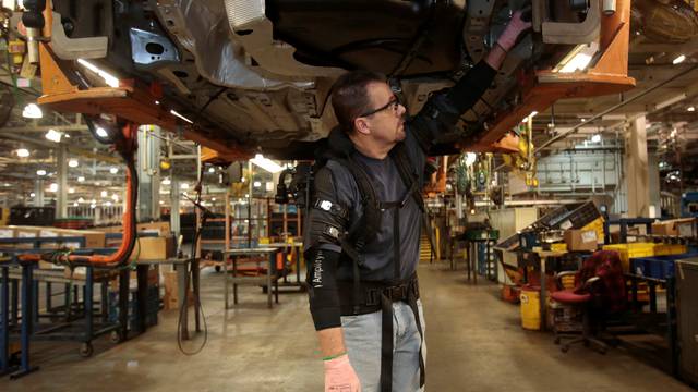 Ford Motor Co assembly worker Paul Collins wears a EksoVest as he works on the assembly line producing the Ford Focus and C-max at Wayne Assembly plant
