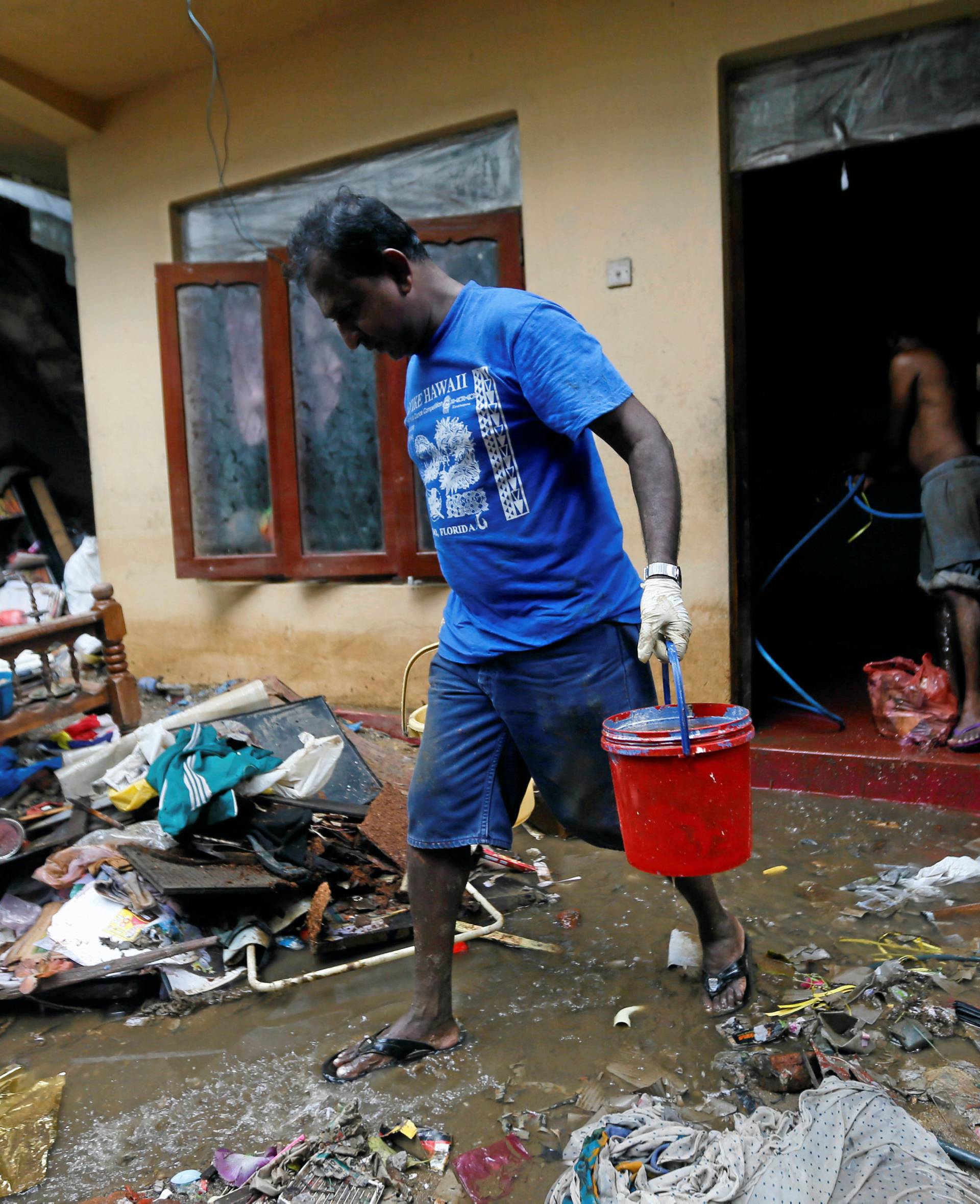 A man cleans his house which was affected by the floods in Biyagama, Sri Lanka