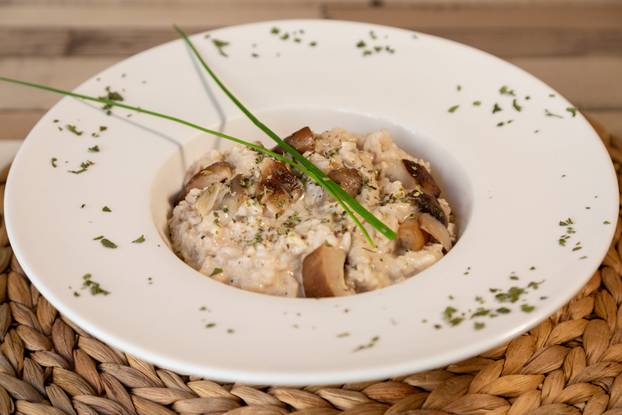 A plate of risotto in a wooden table