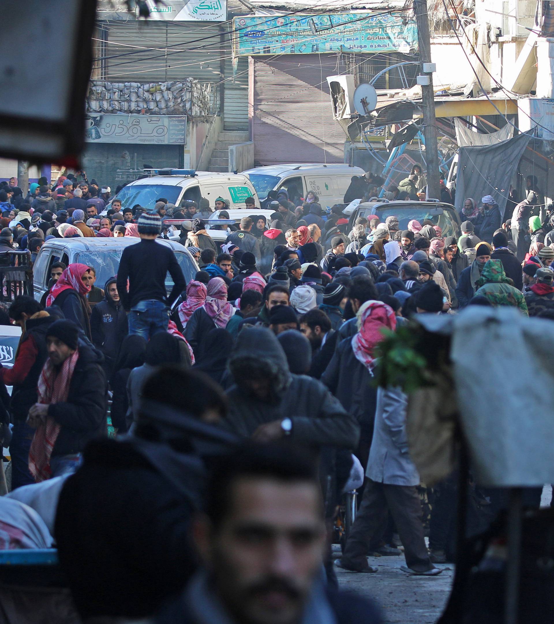 People gather to be evacuated from al-Sukkari rebel-held sector of eastern Aleppo