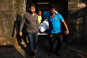Family members and friends carry the body of a victim killed in a fire at a restaurant from a hospital in Mumbai