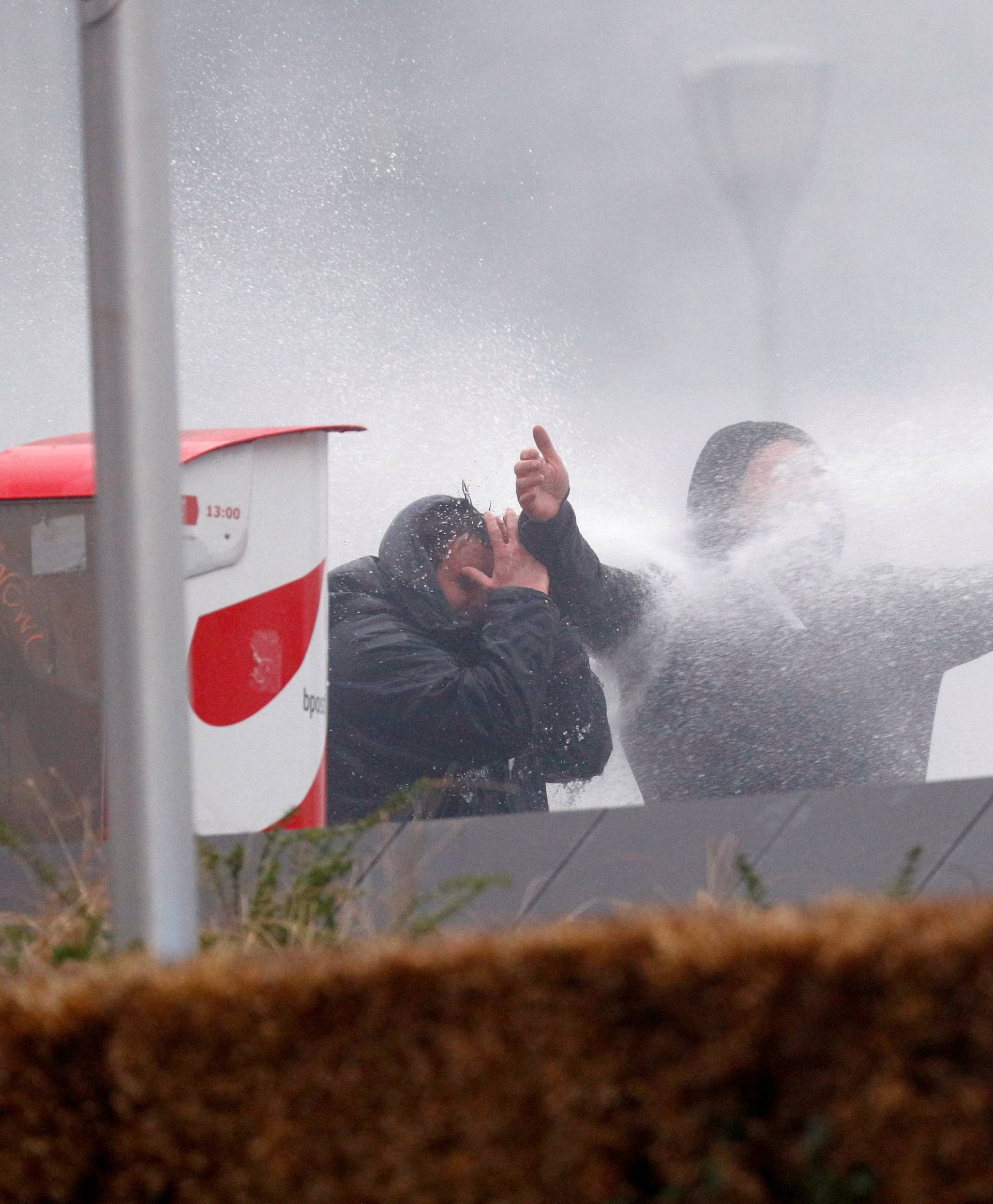 Far-right supporters are sprayed with a water cannon during a protest against Marrakesh Migration Pact in Brussels