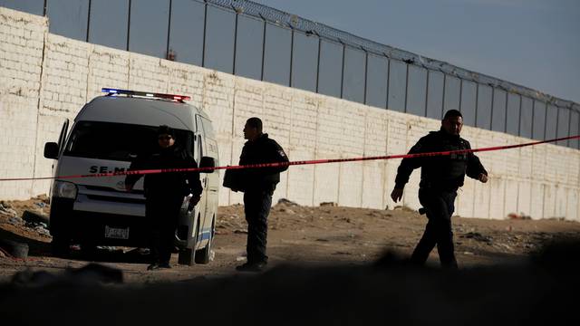 Forensic technicians work at a crime scene where a mutilated body was left by unknown assailants in Ciudad Juarez