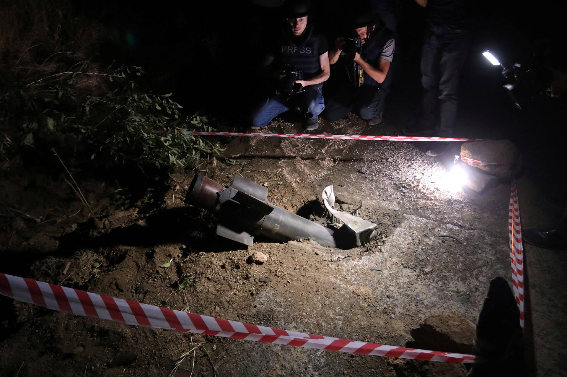 Journalists film the remains of a rocket shell in Jermuk