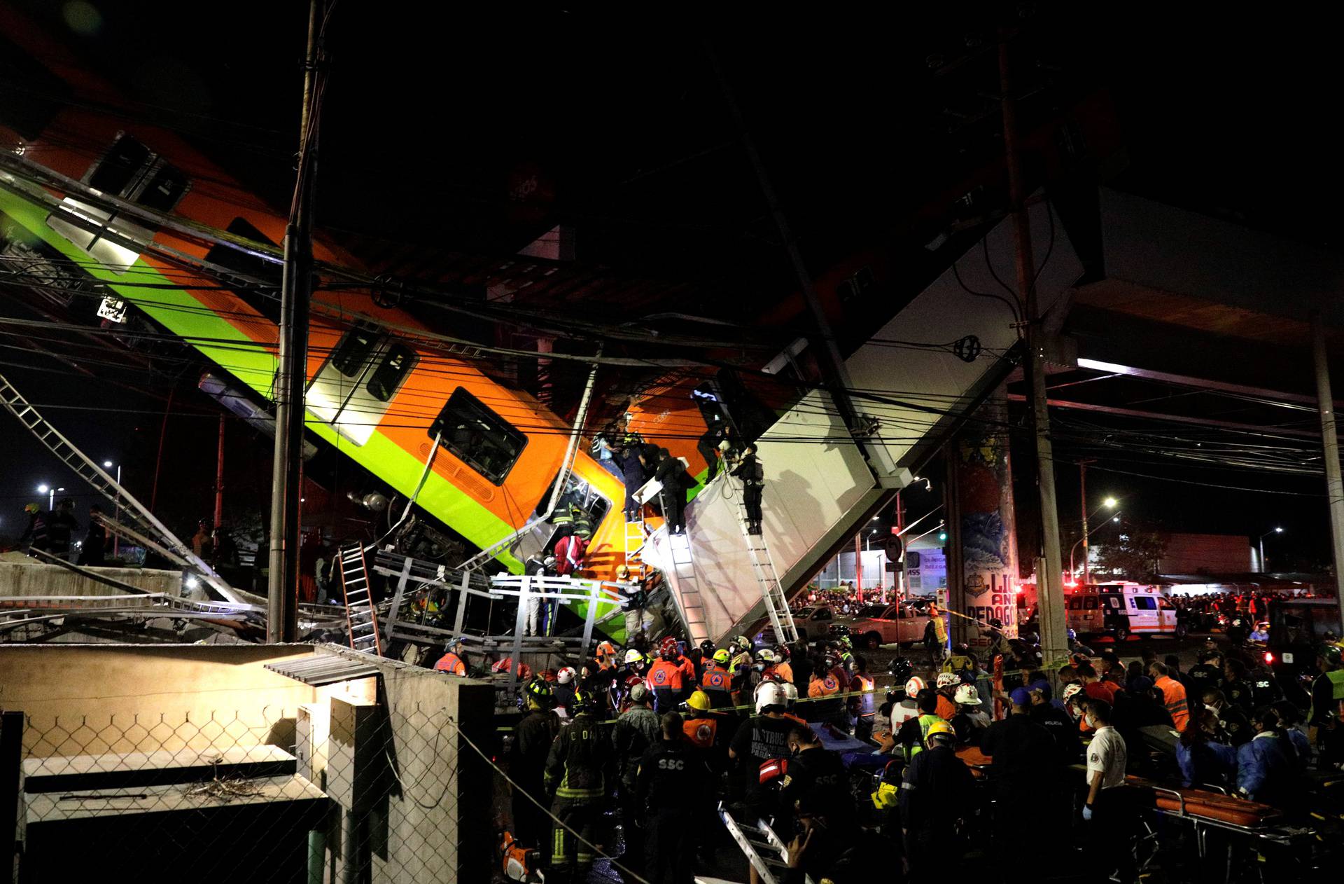Rescuers work at a site where an overpass for a metro partially collapsed with train cars on it at Olivos station in Mexico City