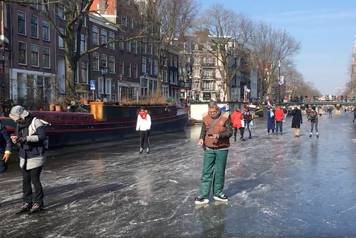 People skate on the frozen canal in Amsterdam