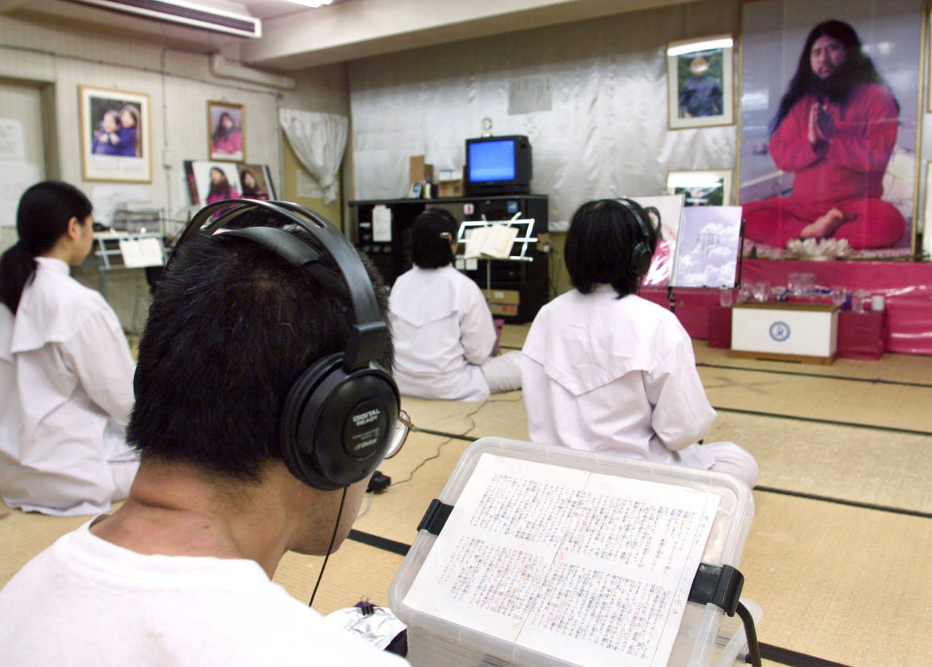 FILE PHOTO : Doomsday cult Aum Shinrikyo followers chant in religious training before a portrait of guru Shoko Asahara at Aum's Adachi office in Tokyo