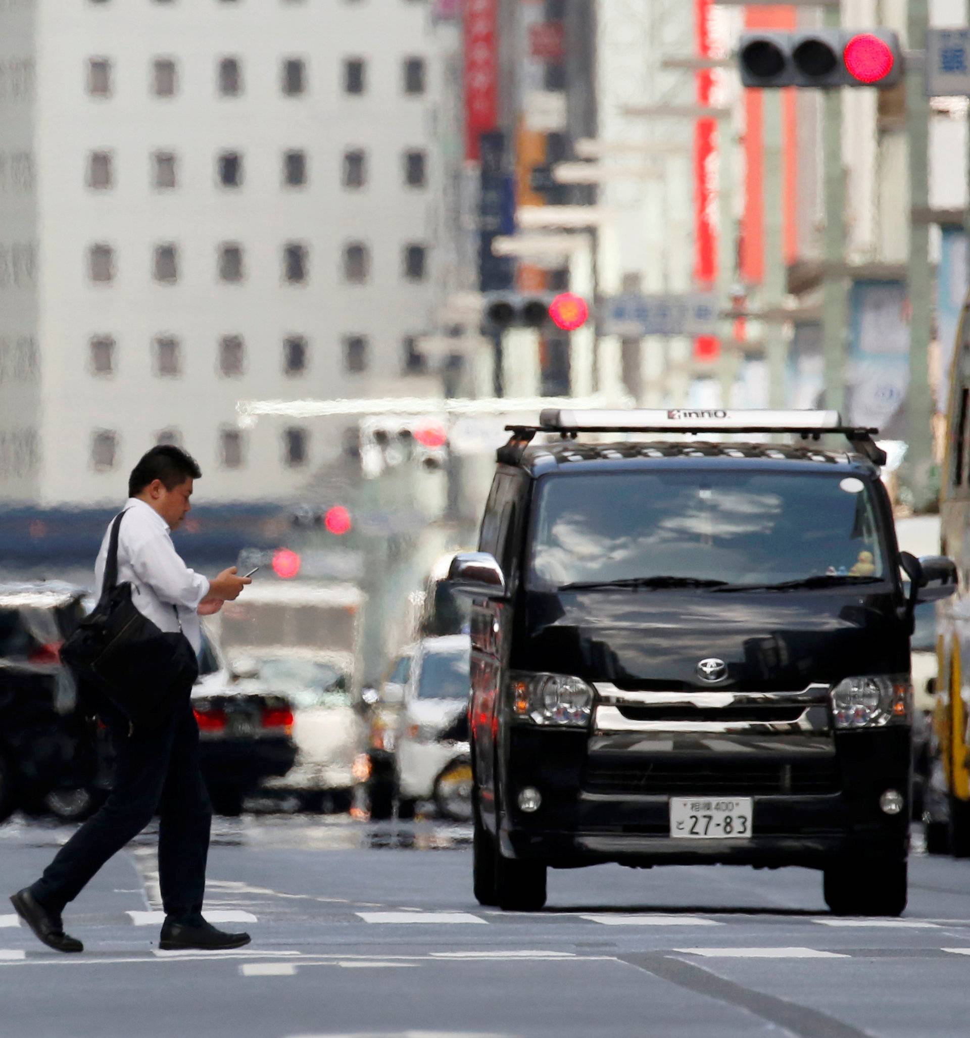 A businessman walks on a street in a heat haze during a heatwave in Tokyo