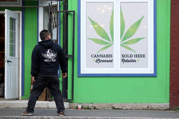 A man looks at a sign outside the Natural Vibe store after legal recreational marijuana went on sale in St John