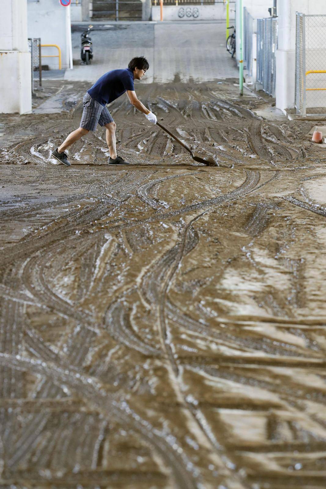 A local resident cleans an area affected by the flood caused by Typhoon Hagibis at Setagaya ward in Tokyo
