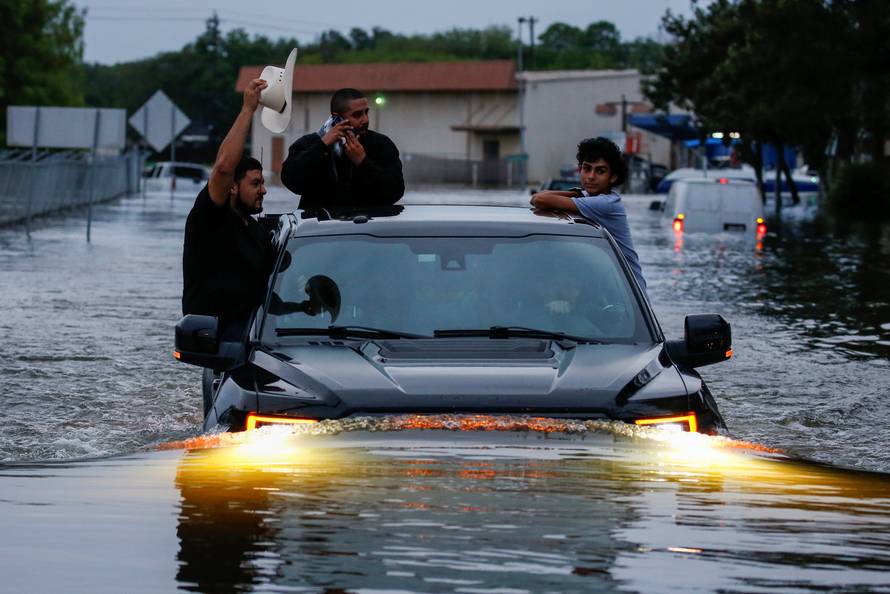 Residents use a truck to navigate through flood waters from Tropical Storm Harvey in Houston, Texas,