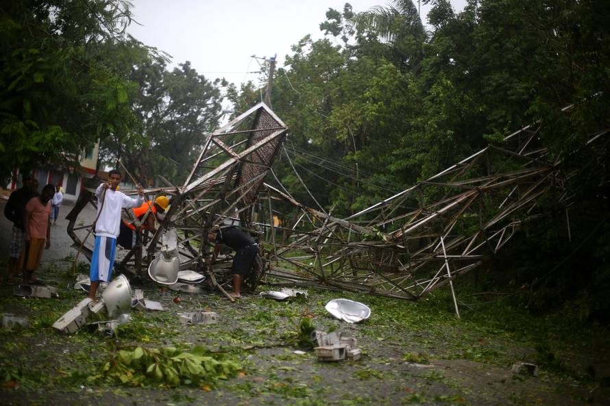 Locals remove pieces from a fallen stadium lighting tower as Hurricane Irma moves off the northern coast of the Dominican Republic, in Puerto Plata