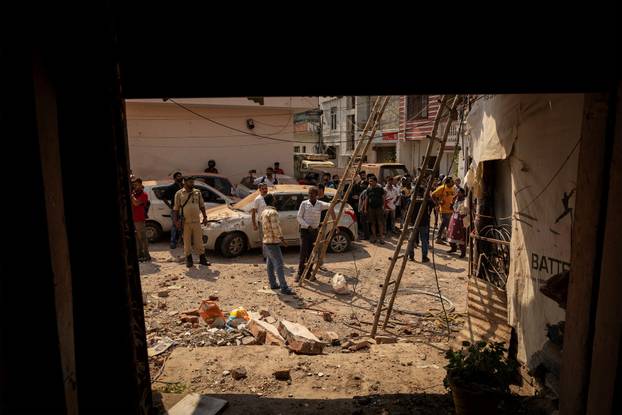 People gather outside a damaged house, following Pakistan's military operation against India, in Rehari, Jammu