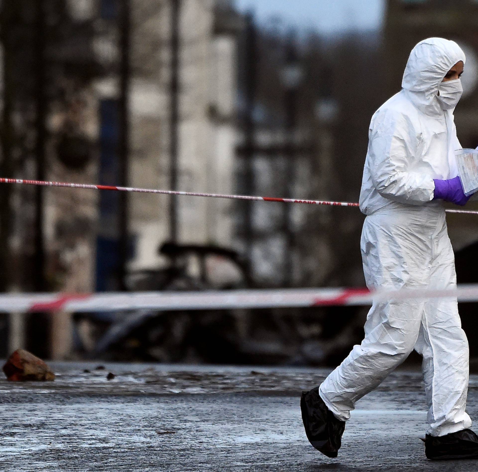 Forensic officer inspects the scene of a suspected car bomb in Londonderry