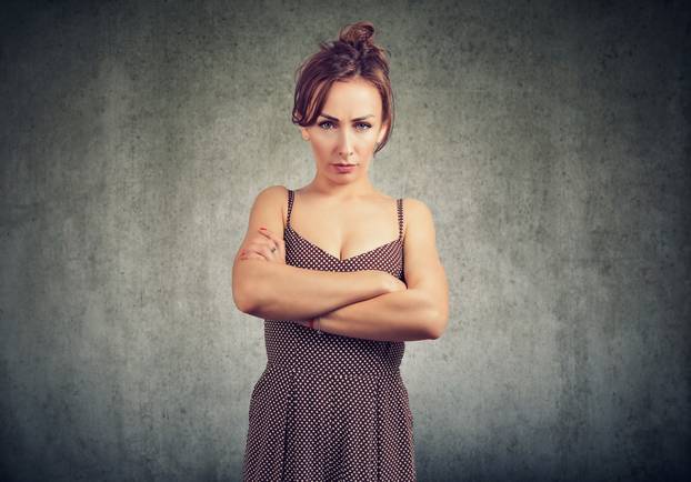 Frowning offended woman with hands crossed