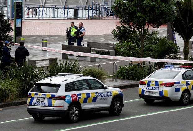 Armed police stand guard near a construction site following a shooting in the central business district, in Auckland