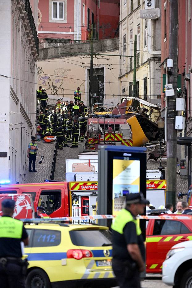 First responders work at the site of a funicular accident in Lisbon