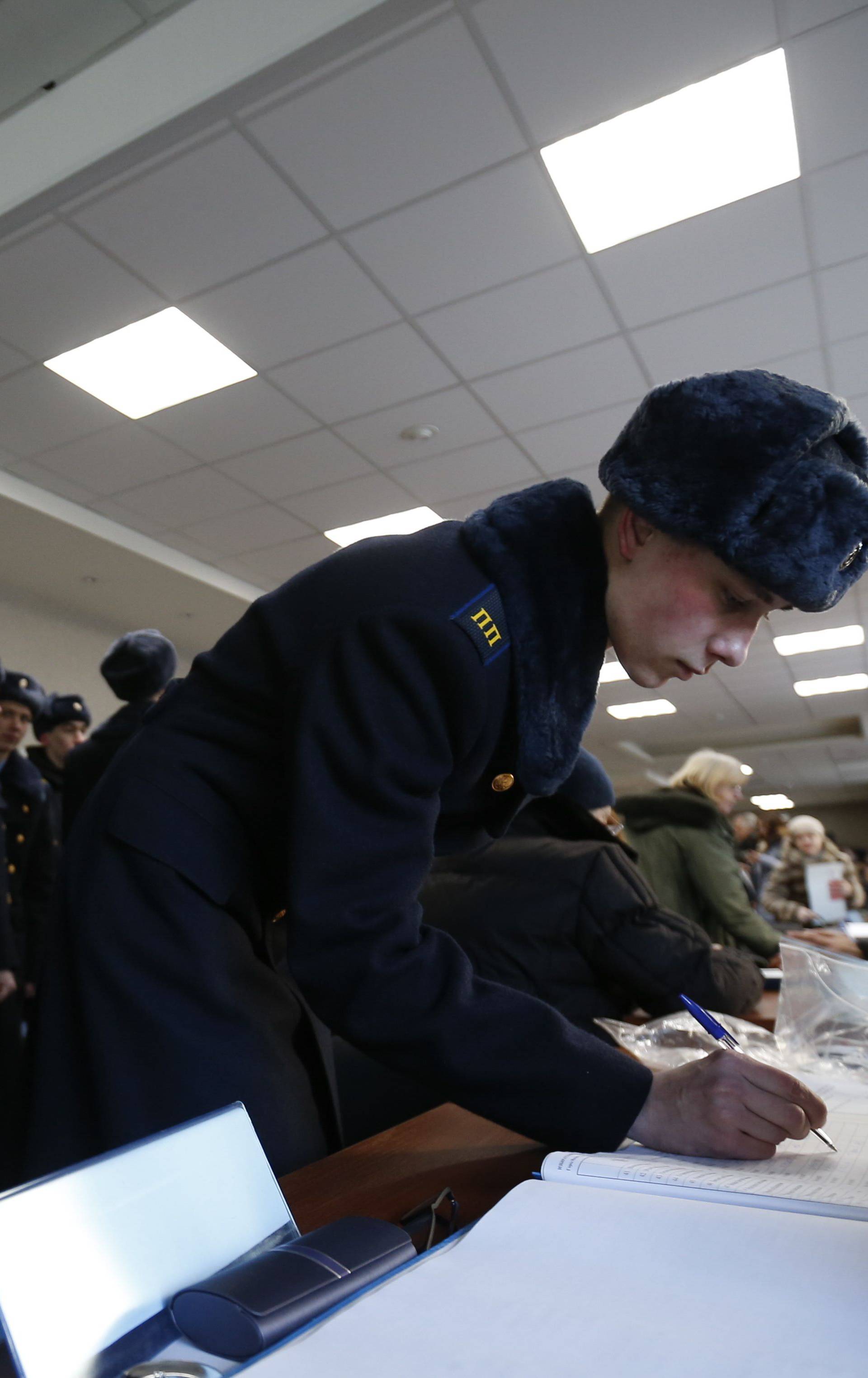 Servicemen of the Presidential Regiment visit a polling station to cast their votes during the presidential election in Moscow