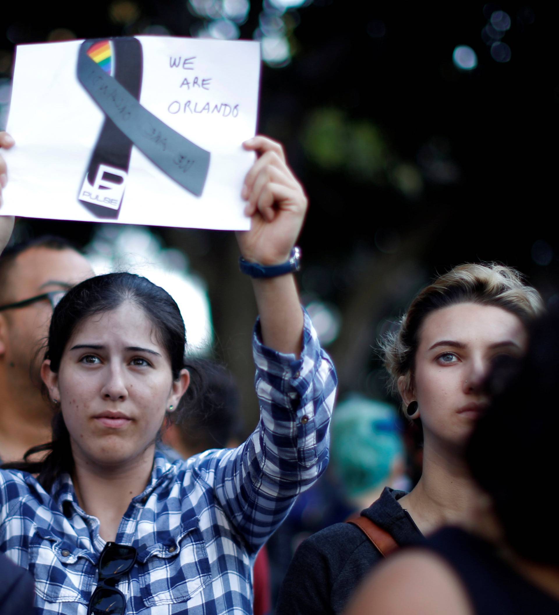 People attend a vigil in memory of victims one day after a mass shooting at the Pulse gay night club in Orlando, in Los Angeles