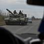 Ukrainian servicemen ride in a tank along a road near a frontline in Zaporizhzhia region