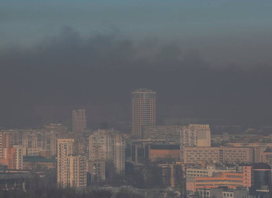 Residential buildings in Kyiv are seen through smoke from fires after shelling nearby