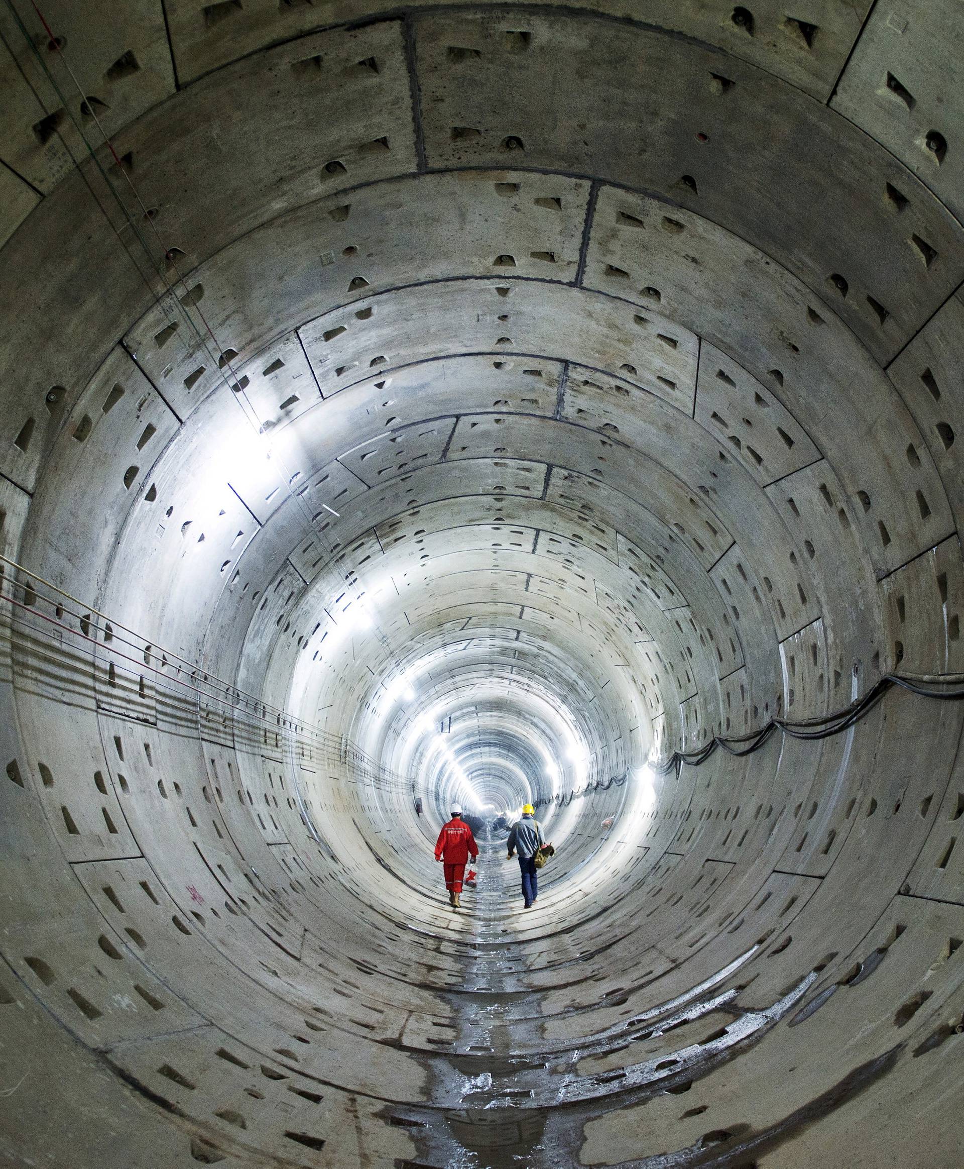 Workers walk along a tunnel of a subway construction site in Changsha, Hunan province