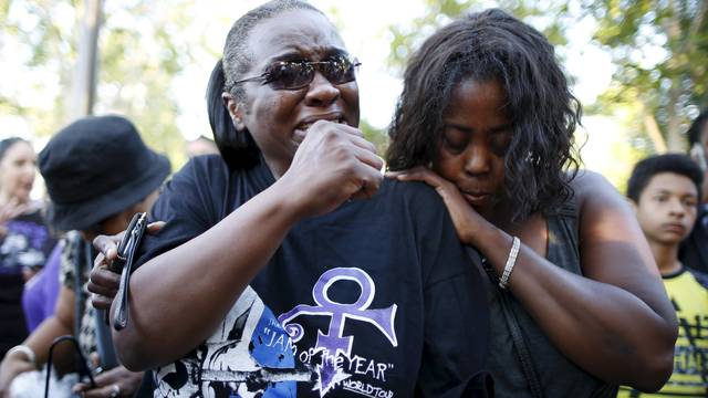 Loretta Thomas, 45, and Deshone, 50, listen to a Prince song at a vigil to celebrate the life and music of deceased musician Prince in Los Angeles