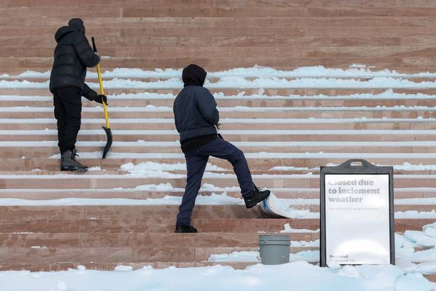 Workers shovel the steps of the National Gallery of Art after a winter storm in Washington