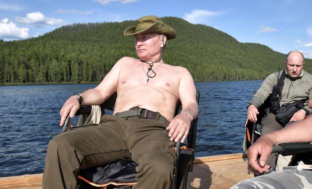 FILE PHOTO: Russian President Vladimir Putin and Defence Minister Sergei Shoigu rest during the hunting and fishing trip which took place on August 1-3 in the republic of Tyva in southern Siberia