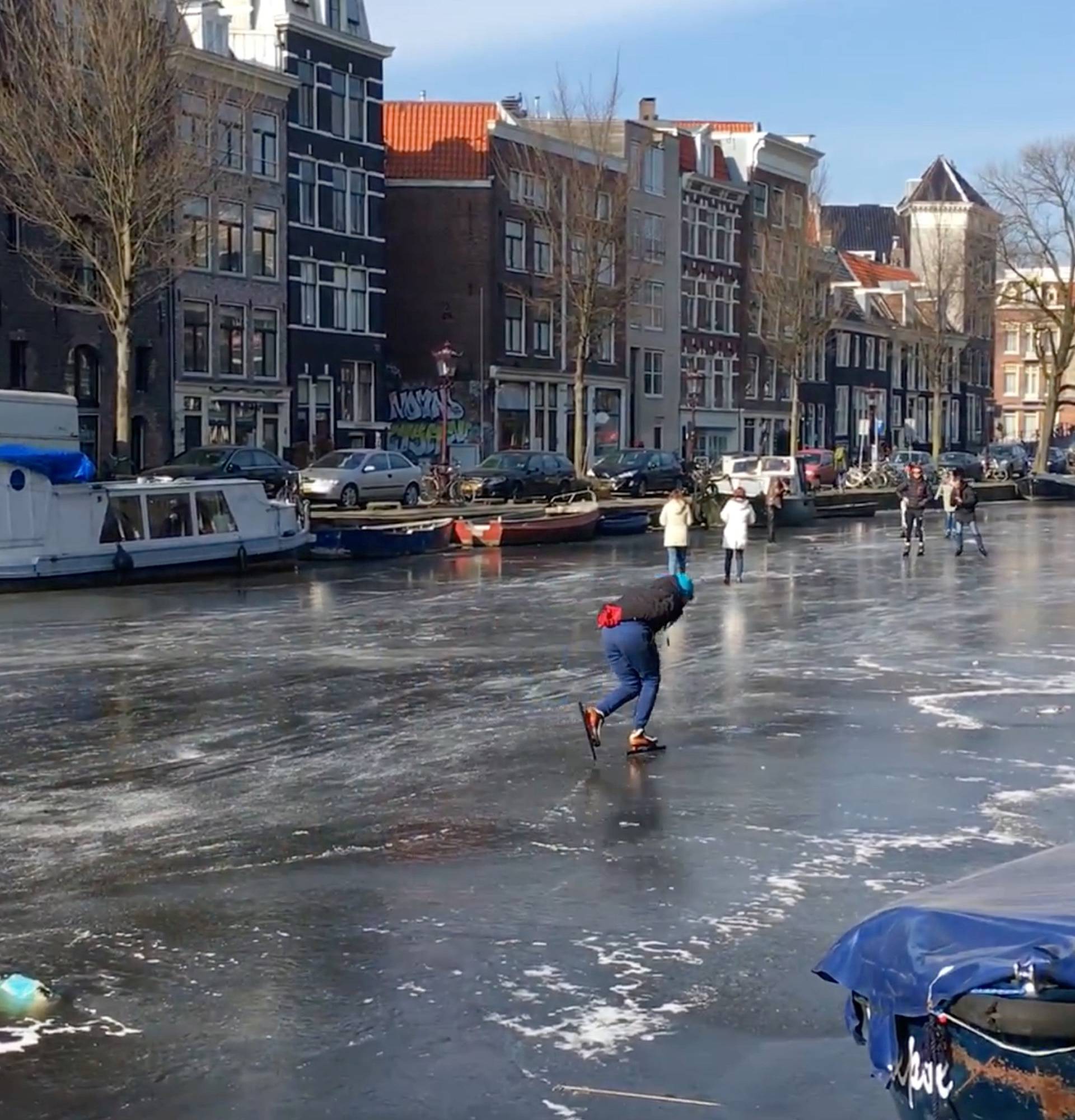 People skate on the frozen canal in Amsterdam