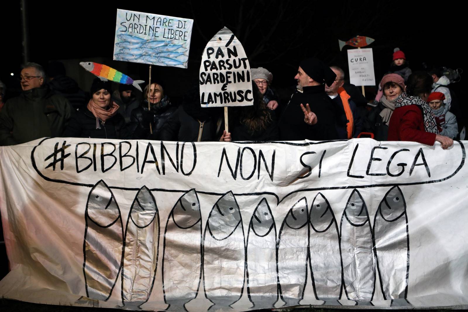 Supporters of 'the sardines', a grassroots movement against far-right League leader Matteo Salvini, hold placards and a banner during a demonstration in Bibbiano