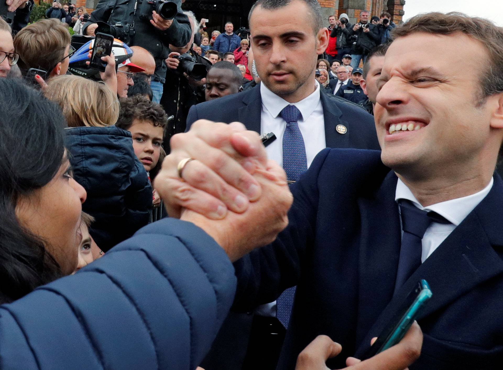French presidential election candidate Emmanuel Macron greets supporters as leaves a polling station during the the second round of 2017 French presidential election, in Le Touquet