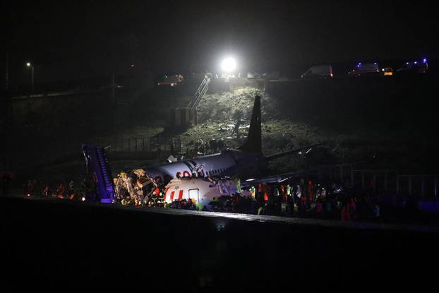 Firefighters and rescue teams are seen next to the wreckage of a plane after it crashed at Sabiha Gokcen airport in Istanbul