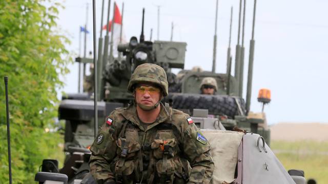 Polish army soldier sits in his armoured fighting vehicle convoy during their ride in Suwalki
