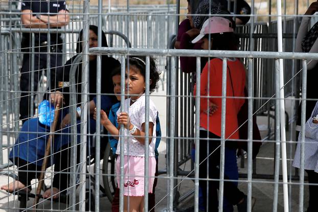 Refugees and migrants wait to take part in a pre-registration process that gives them access to the asylum procedure, at the premises of the disused Hellenikon airport, in Athens