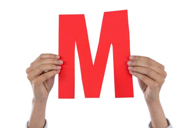 Businesswoman holding an alphabet M