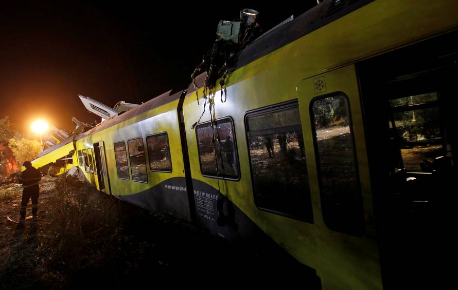 A rescuer works at the site where two passenger trains collided in the middle of an olive grove in the southern village of Corato
