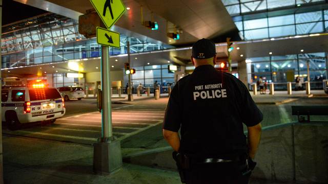 Members of the Port Authority Police Department stand guard at Terminal 8 at John F. Kennedy airport in the Queens borough of New York City