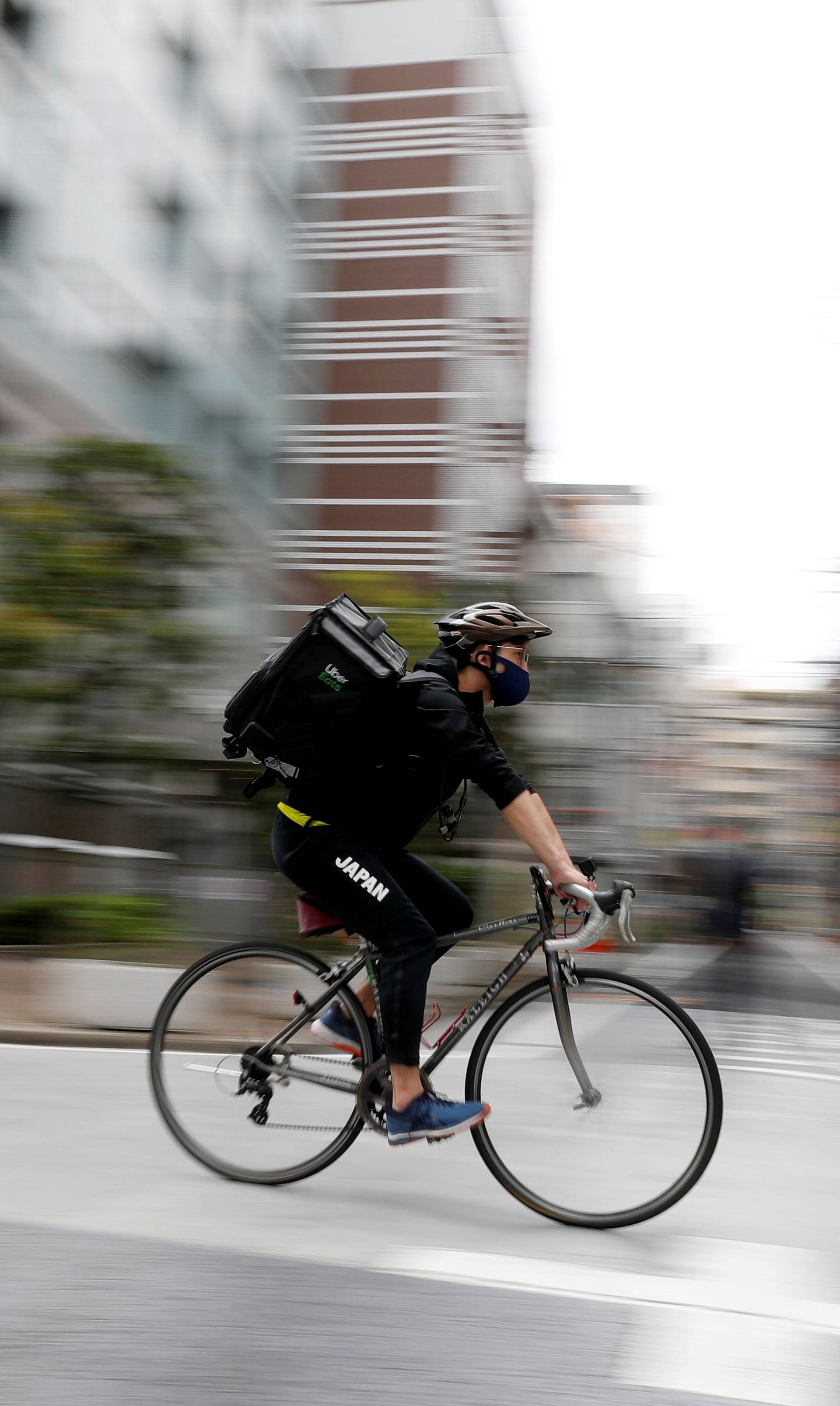 Japan's Olympic fencing medallist Ryo Miyake cycles as he works his part-time job as Uber Eats delivery person as the spread of the coronavirus disease (COVID-19) continues in Tokyo