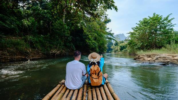 Two,Travelers,Enjoy,A,Peaceful,Bamboo,Rafting,Experience,On,A