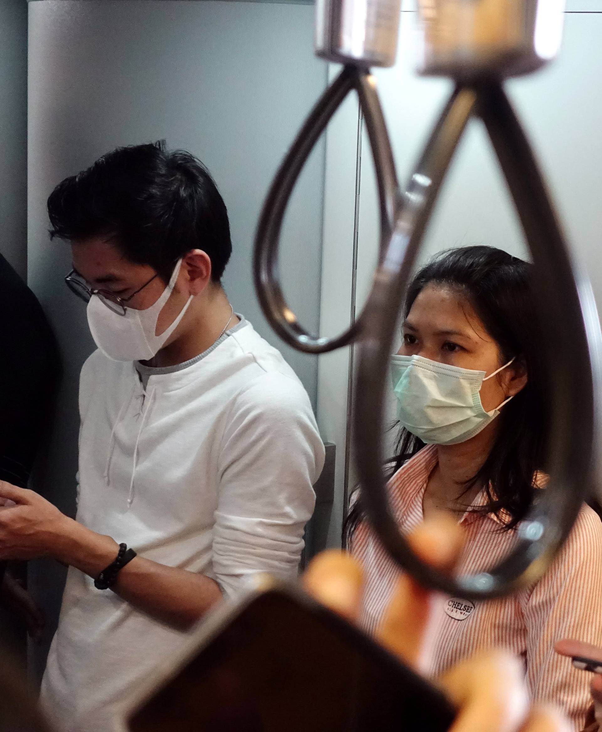People wear masks as they commute to work, after the particulate matter (PM) reached hazardous levels in Bangkok